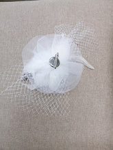 BBFAC2 Classic, elegant white fascinator with central flower, feathers and net.